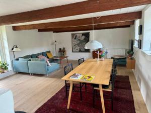 a living room with a table and a blue couch at Fred & Lyst in Stenløse +21 photos