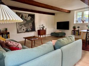 a living room with a blue couch and a tv at Fred & Lyst in Stenløse