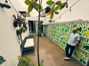 Ein Mann steht auf dem Balkon eines Gebäudes in der Unterkunft Casa Mangle in Tepic