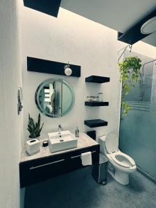 ein Badezimmer mit Waschbecken, Toilette und Spiegel in der Unterkunft Casa Mangle in Tepic