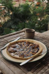 a pizza on a plate on a table at Diki Bungalows in Kuta Lombok