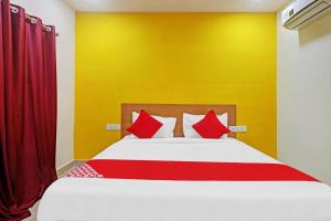 a bedroom with a large bed with red pillows at Hotel O Langar Houz Near Golconda Fort in Hyderabad