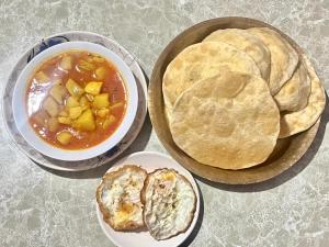 a table with two plates of food with soup and bread at Riyang Homestay in Mirik