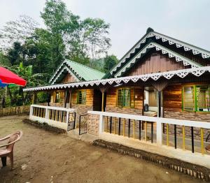 a wooden house with a chair in front of it at Riyang Homestay in Mirik