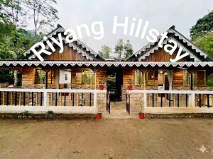 a wooden house with a sign that readsryan hills farm at Riyang Homestay in Mirik