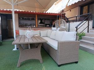 a wicker couch and a table on a patio at Morfeas apartments in Sarti