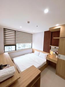 a bedroom with a bed and a desk and a window at Minh Anh Apartment 5 in Thôn Văn Dương