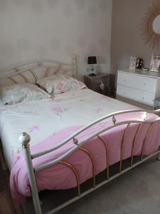 a bedroom with a bed with a pink and white blanket at Chambre sérénité in Moult +13 photos