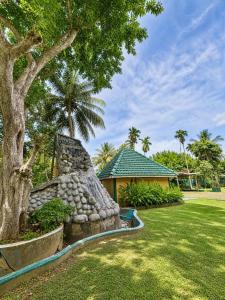 a yard with a stone wall next to a house at Vegas Nature Resort in Dankotuwa