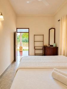 a bedroom with a large bed and a mirror at Vegas Nature Resort in Dankotuwa