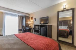 a hotel room with a bed and a mirror at Comfort Inn Trenton in Trenton +24 photos