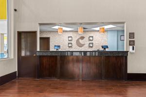 a hotel lobby with a reception counter and a mirror at Comfort Inn & Suites Airport South in Calgary +49 photos