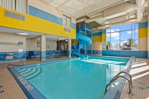 a swimming pool with a slide in a building at Comfort Inn & Suites Airport South in Calgary