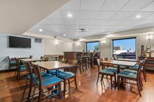a restaurant with tables and chairs and a flat screen tv at Comfort Inn & Suites Airport South in Calgary