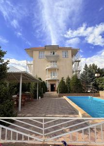 a large building with a swimming pool in front of it at Intour in Cholpon-Ata