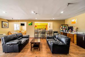 a living room with black leather furniture and a kitchen at Quality Inn Carbondale University area in Carbondale
