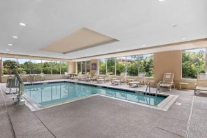 a pool in a hotel room with chairs and tables at Comfort Suites Manassas Battlefield Park in Manassas
