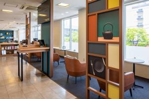an office lobby with desks and chairs and a table at Comfort Hotel Tsubamesanjo in Sanjo