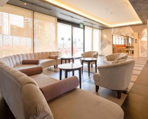 a waiting room with couches and tables and windows at Comfort Hotel ERA Ise in Ise