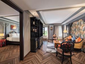 a bedroom with a bed and a living room with a couch at THE LEGEND HANOI Hotel in Hanoi +64 photos
