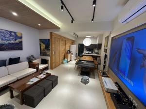 a living room with a couch and a large screen tv at 喜滿家民宿 in Zhuqi