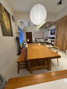 a dining room with a wooden table and chairs at 喜滿家民宿 in Zhuqi