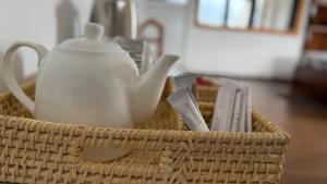 a wicker basket with a tea kettle and other items at Medalin Lake Gregory in Nuwara Eliya