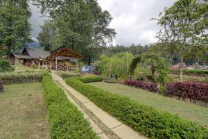 a garden with a house in the background at Kampoeng Regang By BHATARA in Patengan