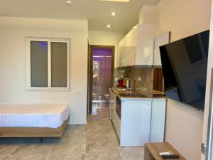 a room with a bed and a kitchen with a television at Milaluxe in Paralia Katerinis