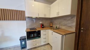 a kitchen with white cabinets and a sink at Milaluxe in Paralia Katerinis