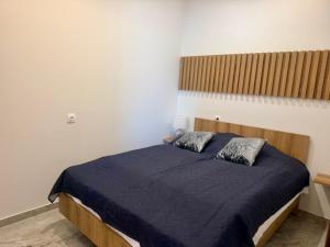 a bedroom with a bed with a blue blanket at Milaluxe in Paralia Katerinis