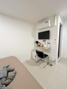 a white room with a desk and a chair at SJ Beach House Patong in Patong Beach