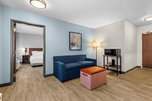 a living room with a blue couch and a bed at Everhome Suites Temecula Wine Country in Temecula