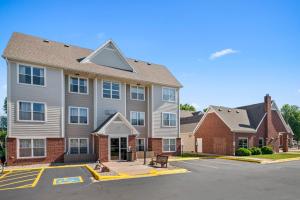a large apartment building with a parking lot at MainStay Suites Appleton Airport - Fox River Mall Area in Appleton