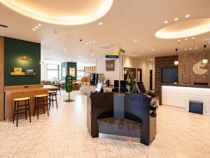 a lobby with a bar and some tables and chairs at Comfort Hotel Chitose in Chitose