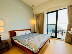 a bedroom with a bed and a large window at 喜滿家民宿 in Zhuqi