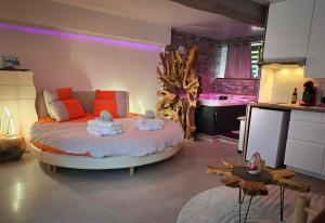 a bedroom with a large bed with orange pillows at Domaine de la Besnerie Gites avec SPA Privatif à 10 min du Mont St Michel in Tanis