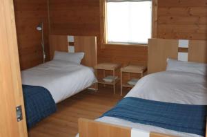 a bedroom with two beds and a window at Alpine Chalets Hakuba in Hakuba