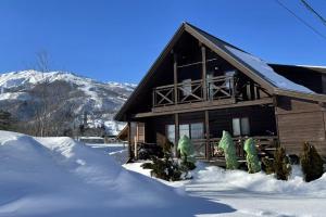 a log cabin with snow in front of it at Alpine Chalets Hakuba in Hakuba