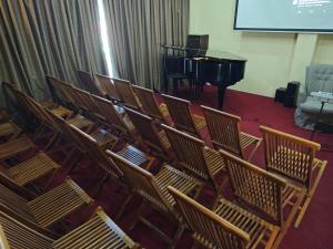 a group of chairs with a piano in a room at Sangria Pinesview Chalet in Baguio