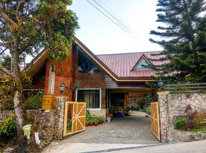 a house with a gate in front of it at Sangria Pinesview Chalet in Baguio