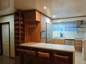 a kitchen with wooden cabinets and a counter top at Sangria Pinesview Chalet in Baguio