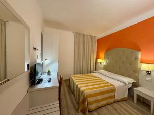 a hotel room with a bed with an orange wall at Camere LAURO ROSSI in Macerata