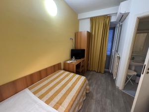 a hotel room with a bed and a television at Camere LAURO ROSSI in Macerata