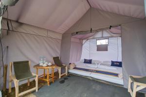 a tent with a bed and two chairs and a table at Kampoeng Regang By BHATARA in Patengan +55 photos