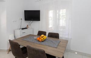 a dining room table with a bowl of fruit on it at First Line Seafront Luxury Apartman Kata in Rogotin