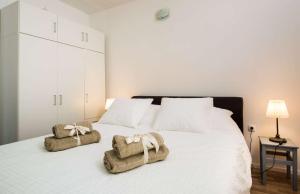a bedroom with a white bed with towels on it at First Line Seafront Luxury Apartman Kata in Rogotin