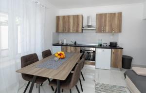 a kitchen with a wooden table and chairs in a room at First Line Seafront Luxury Apartman Kata in Rogotin