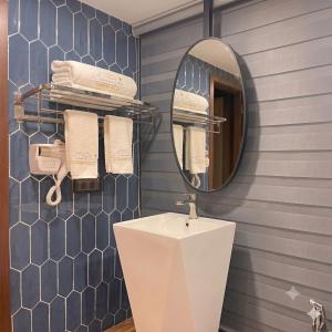 a bathroom with a sink and a mirror and towels at Su House Villa in Gò Ba Quần +4 photos