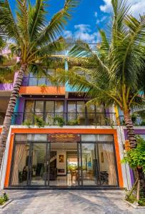 a building with palm trees in front of it at Su House Villa in Gò Ba Quần